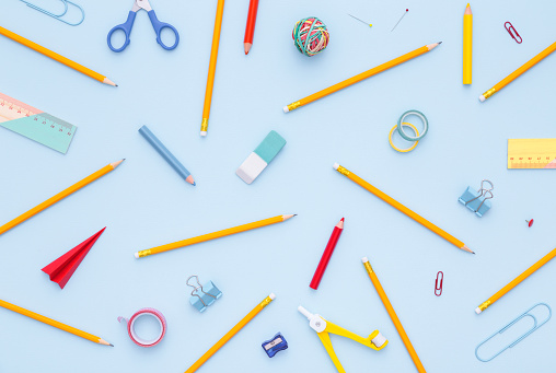 Variety of school supplies on the blue background. Back to school concept. Flatly, directly above.