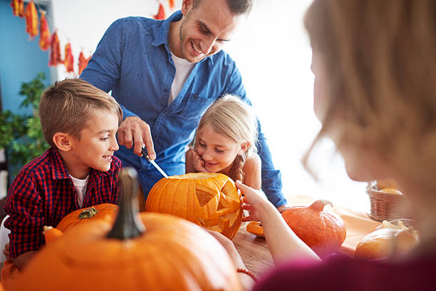 istock Father helping in drilling pumpkins 603305230