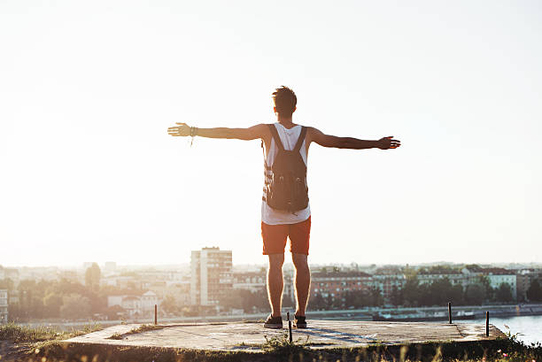 istock Young man standing on the cliff with a city view 603310766
