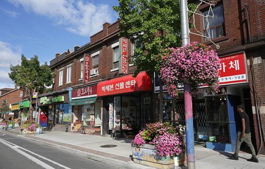 Toronto, Canada - August 21, 2016: Korea Town Businesses, Bloor Street in Seaton Village Neighbourhood, Toronto, Canada. Multi-ethnic grocery stores, gift shops and restaurants line the 600-block Bloor Street West. Pedestrians walk through the popular commercial district on a summer morning. 