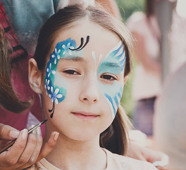 istock Female child face painting, making butterfly process 603314262