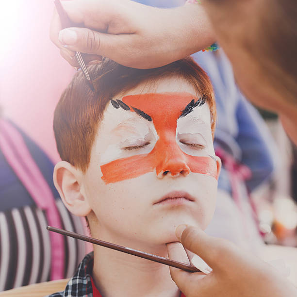 istock Child boy face painting, making tiger eyes process 603314438
