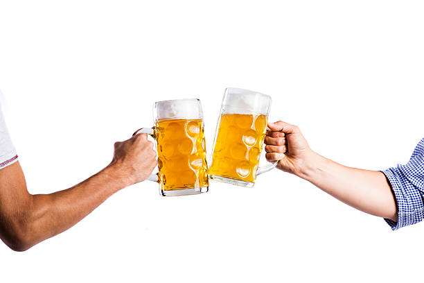 dos hombres irreconocibles parpadeando con tazas de cerveza, foto de estudio - clunking fotografías e imágenes de stock