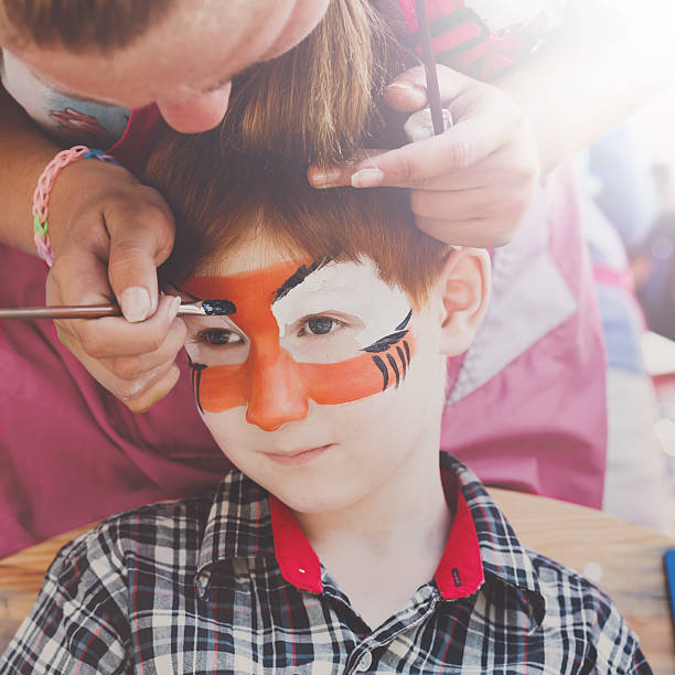 istock Child boy face painting, making tiger eyes process 603314482