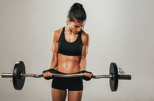 istock Strong young woman lifting barbell 603315358