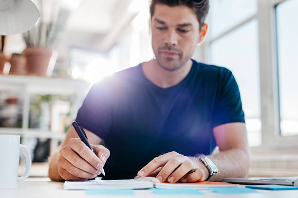 istock Young businessman updating his personal organizer 603315654