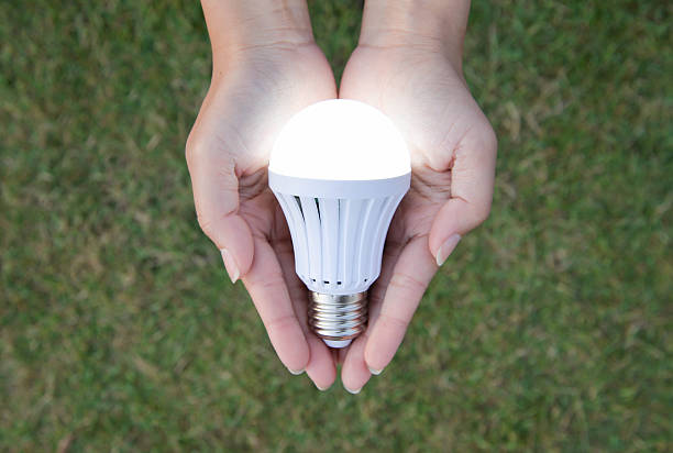 lampadina a led con illuminazione- risparmiando tecnologia in mano - led lighting equipment light bulb installing foto e immagini stock