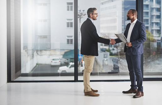 Shot of two businessmen shaking hands at work