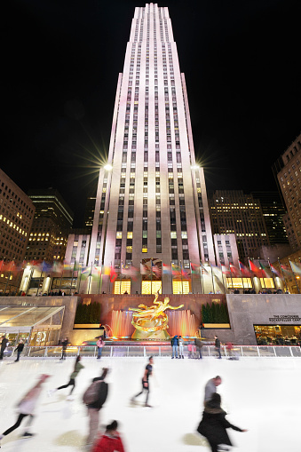 New York City, USA - February 20, 2016: Ice skaters in the lower plaza of the Rockefeller Center which houses the popular ice skating rink and the Bronze sculpture of Prometheus by Paul Manship (c.1934).