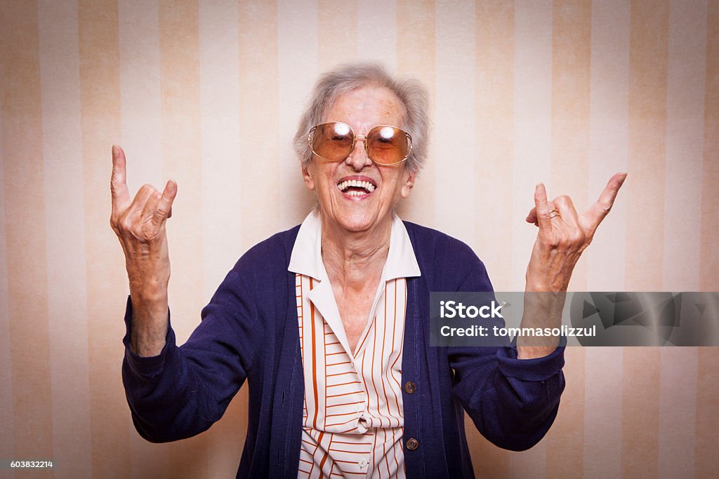 cool elder lady making rock on sign elder lady making rock on sign Cool Attitude Stock Photo