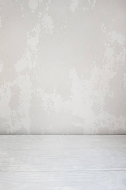 istock White plastered wall and wooden floor background 603839388