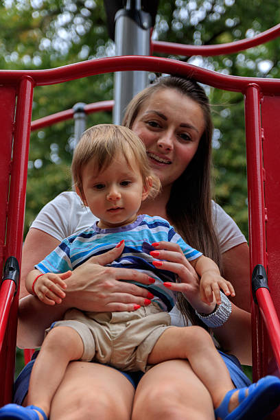 madre con bambino nel parco divertimenti - jelly shoe foto e immagini stock