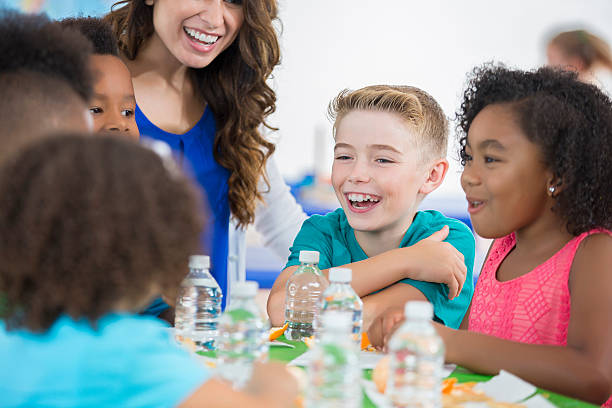 istock Little boy laughing with friends during daycare snack time 603844370