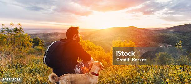 Man With Dog Enjoying Mountain Sunset Stock Photo - Download Image Now - Dog, Men, Hiking