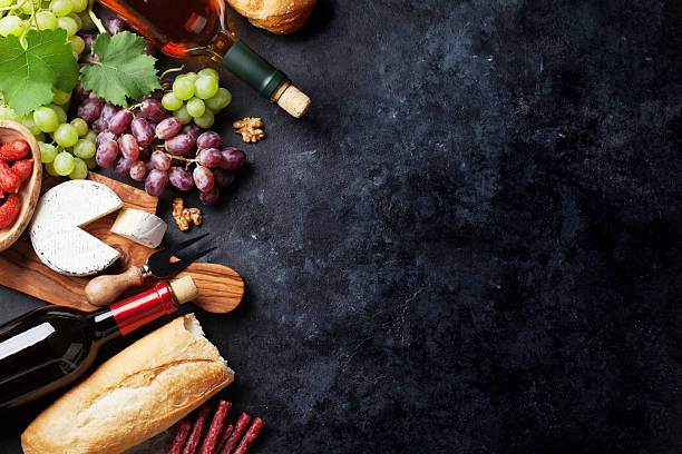 vin rouge et blanc, raisin, fromage et saucisses - fruit stone photos et images de collection