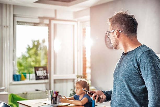 istock Father holding smart phone and looking at daughter 603850978