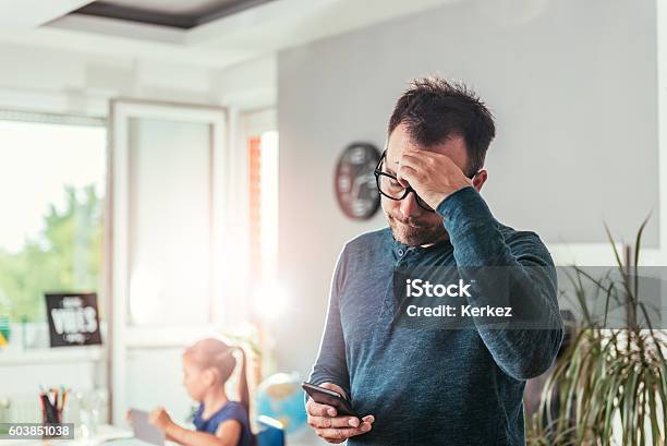 Worried Father Looking At Smart Phone Stock Photo - Download Image Now - Emotional Stress, Worried, Father