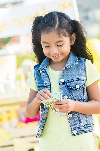 istock Cute Filipino girl counts lemonade profits 603851346