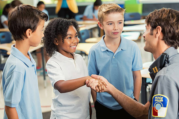 istock Smiling student shakes hands with police officer 603851546