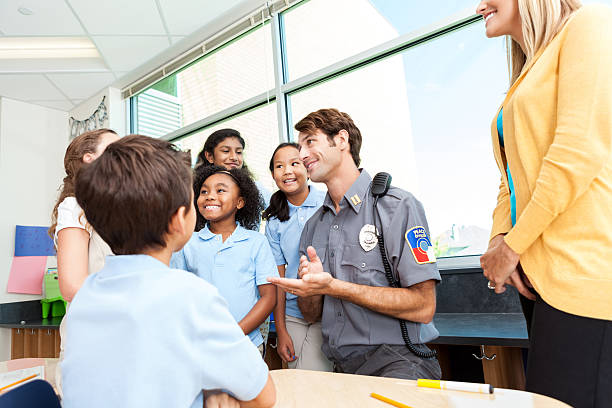 istock Friendly policeman talks with group of private school students 603851566