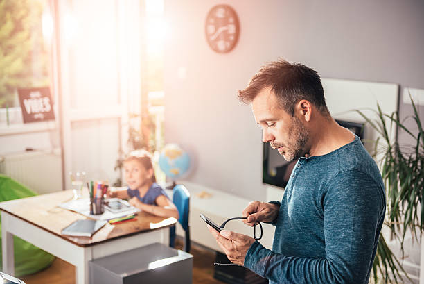 istock Father looking at smart phone 603851888