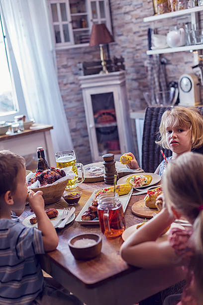 istock Eating Spicy Chicken Wings with Baked Potato and Corn 603852138