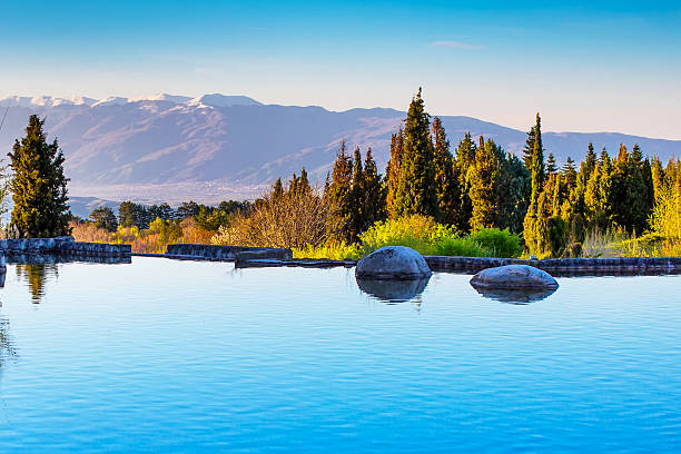 Beautiful landscape view of the lake, trees and snow mountains peaks on the background
