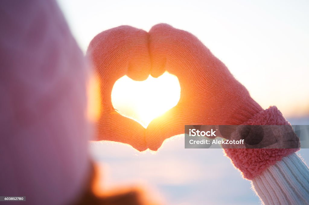 Woman hands in winter gloves Heart symbol Let it snow, greeting card. Woman hands in winter gloves Heart symbol shaped Lifestyle and Feelings concept with sunset light nature on winter background Winter Stock Photo