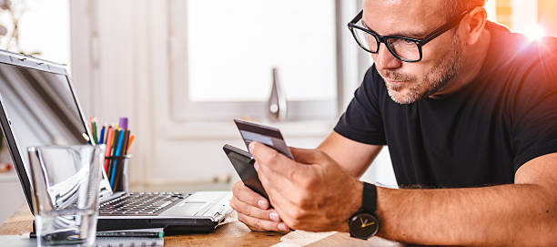 istock Businessman paying with credit card on smart phone 603853378