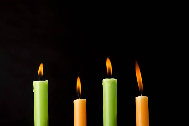 istock Four burning colorful candles on black background 603854602