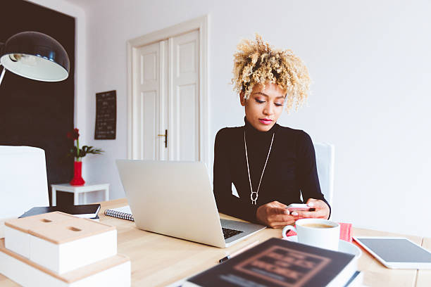 istock Afro american young woman using smart phone in an office 603858402