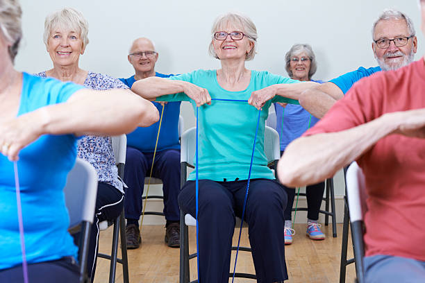 Group Of Seniors Using Resistance Bands In Fitness Class stock photo