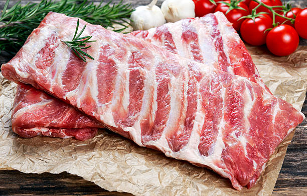 istock Raw ribs with a rosemary and vegetables. on crumpled paper 603860366