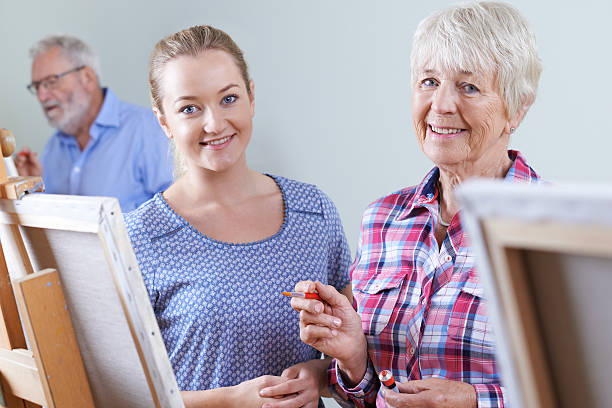 istock Seniors Attending Painting Class With Teacher 603863208