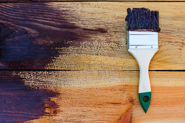 istock Brush on wooden background. Board half painted. 603863706