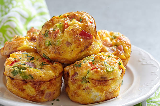 Delicious egg muffins Delicious egg muffins with ham, cheese and vegetables frittata stock pictures, royalty-free photos & images