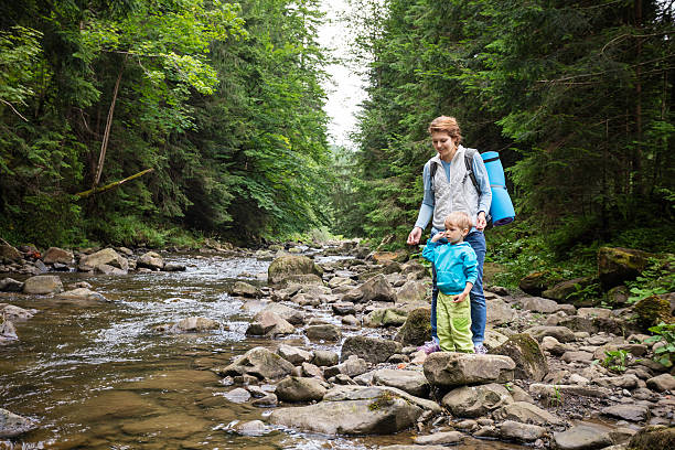 istock Mother and son resting by a stream in mountains 603869130
