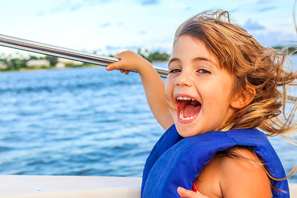 Happy Girl Happy little girl happy and full of energy on a boat ride life jacket stock pictures, royalty-free photos & images