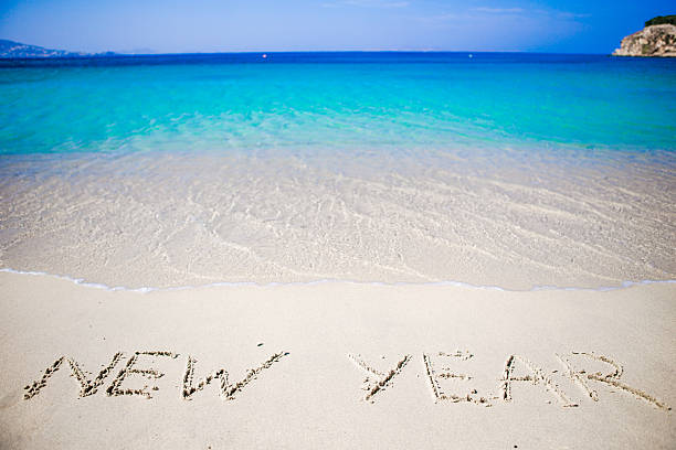 istock Happy New Year written in the white sand 603871334