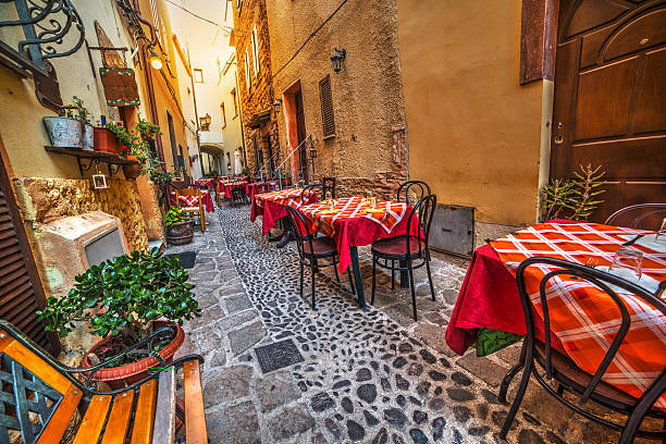 rustic tables and chairs by a trattoria rustic tables and chairs by a trattoria in Sardinia, Italy castelsardo stock pictures, royalty-free photos & images