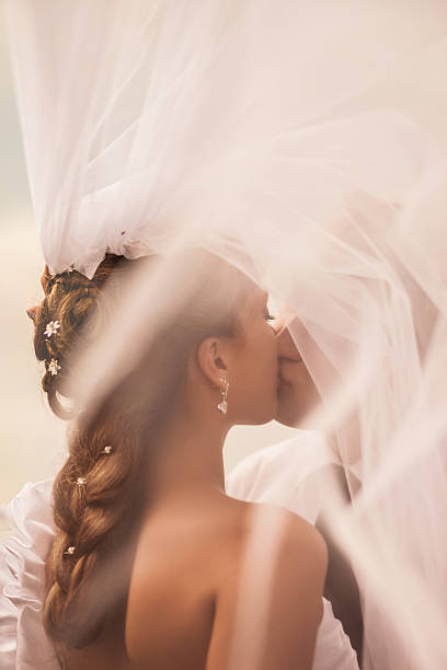 невеста целует жениха под вуалью - vertical single flower women teenager стоковые фото и изображения