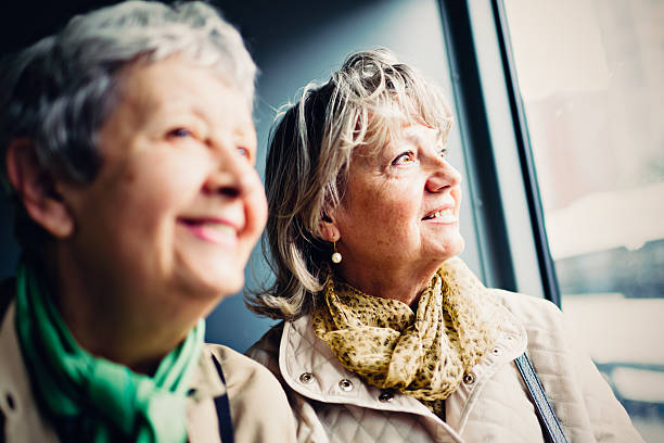 istock Two mature women looking at view from city train 603873266