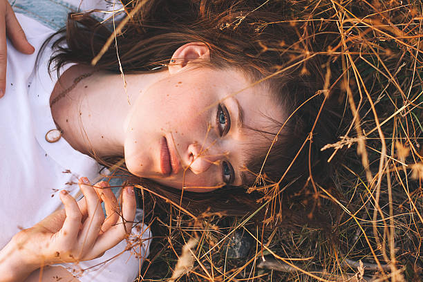 mujer de belleza con cabello castaño en golden field al atardecer. - make up fashion beauty sullen fotografías e imágenes de stock