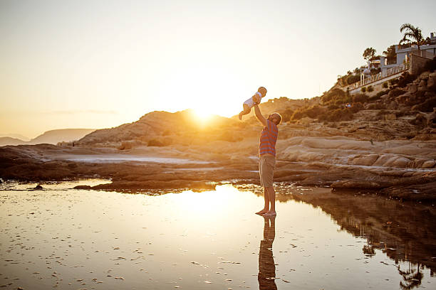 istock Father and his son have fun at the sea beach 603874204