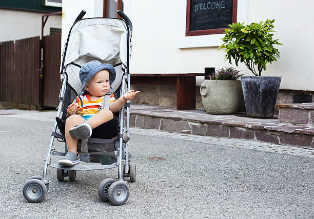 Adorable child toddler in a stroller on the street. Portrait of adorable a child in a stroller on the street. Bled, Slovenia. European streets, summer atmosphere, leisure and travel. gorenjska stock pictures, royalty-free photos & images
