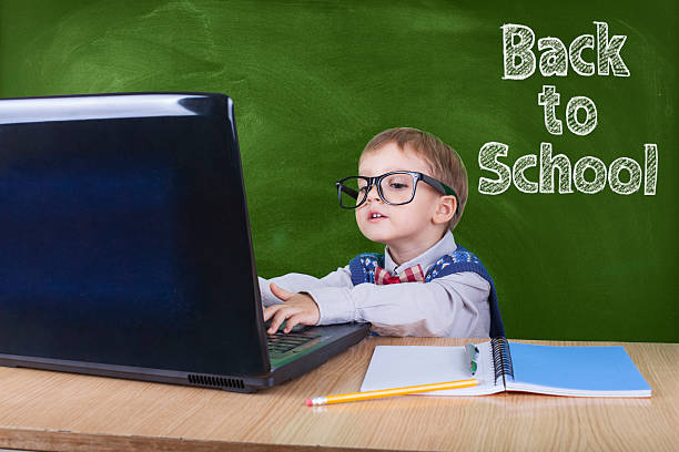 istock Child with laptop peeking in the classroom 603898110