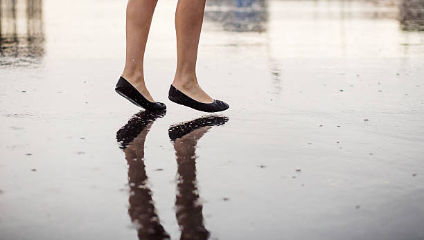 istock Woman legs and rain drops on asphalt 603899798