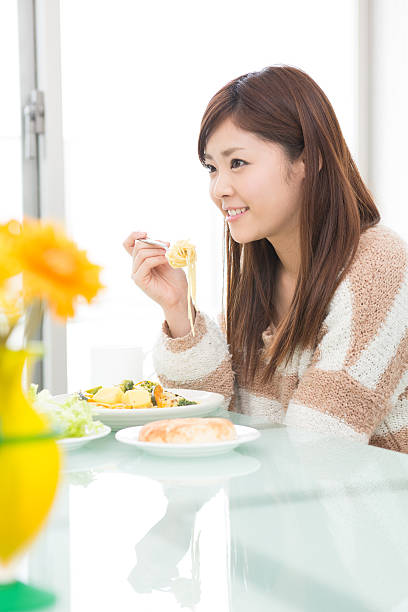 istock young attractive asian woman who  eats 603901086