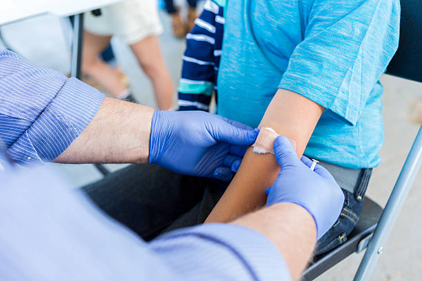 istock Volunteer doctor placing a bandaid on a young patient 603901220