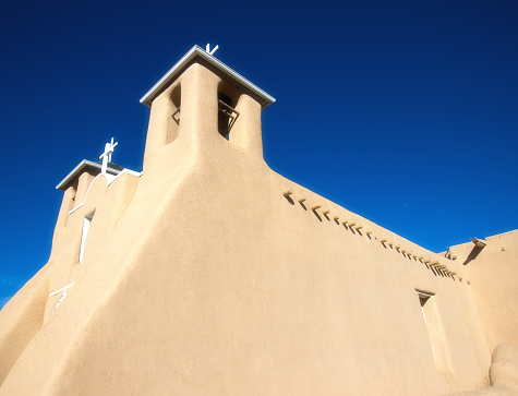 Ranchos de Taos church (San Francisco de Asis Mission Church) in early morning light.   Completed in 1816, the raw adobe church is located just outside Taos, New Mexico. Copy space in the sky.
